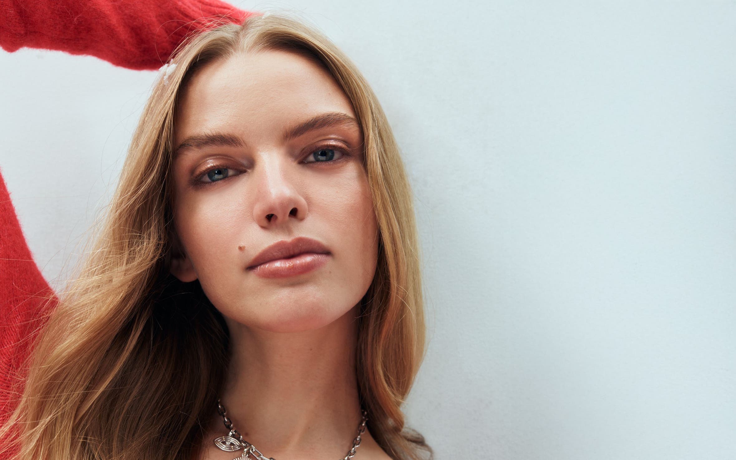 A woman wearing a charm necklace.