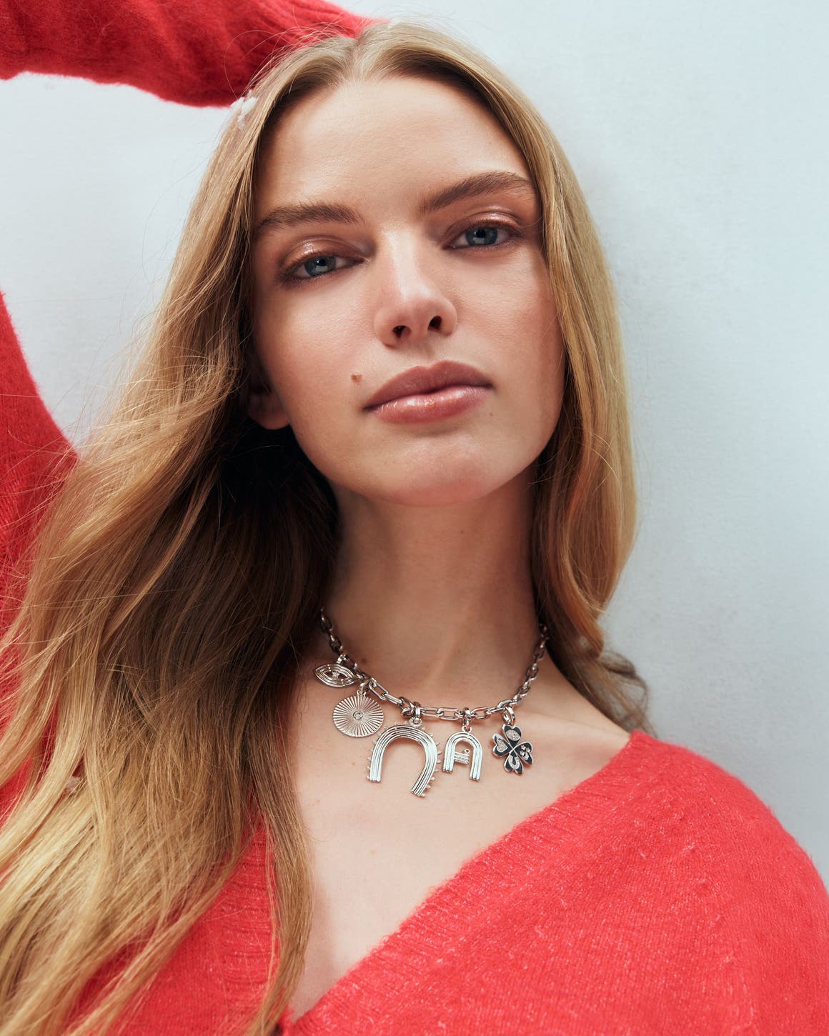 A woman wearing a charm necklace.