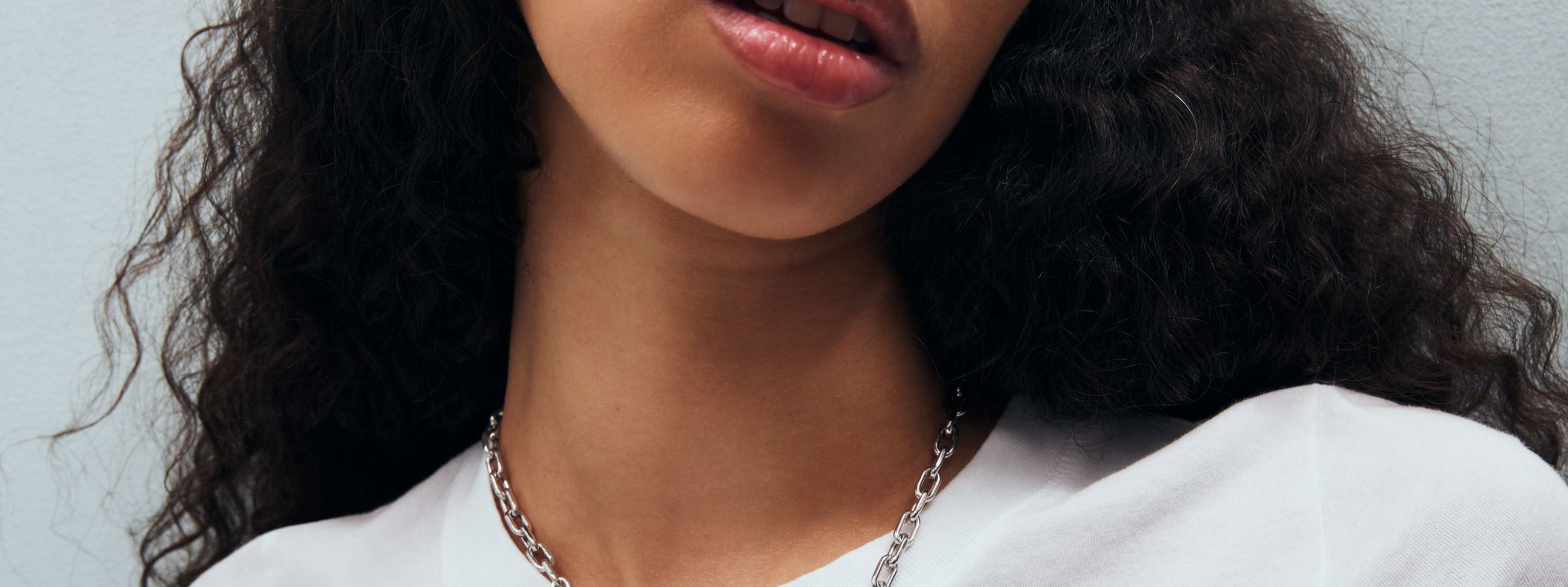 A woman wearing a charm necklace.