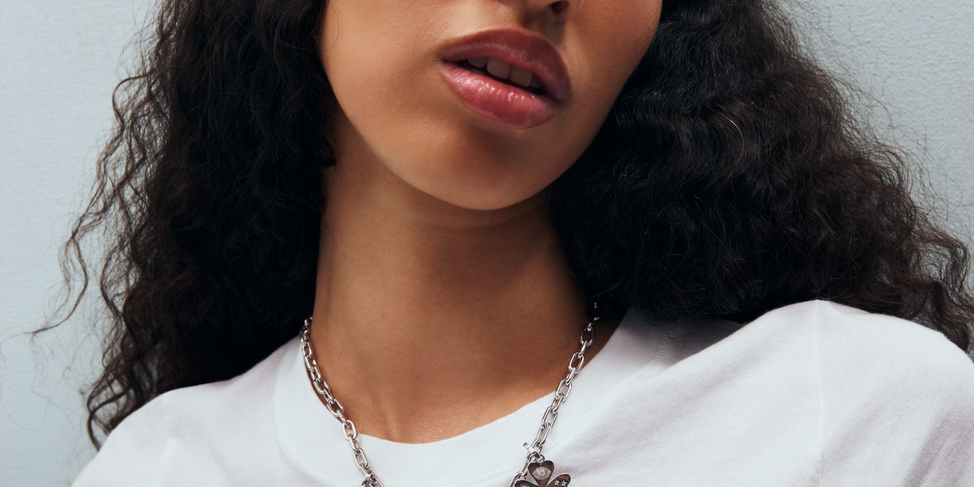 A woman wearing a charm necklace.