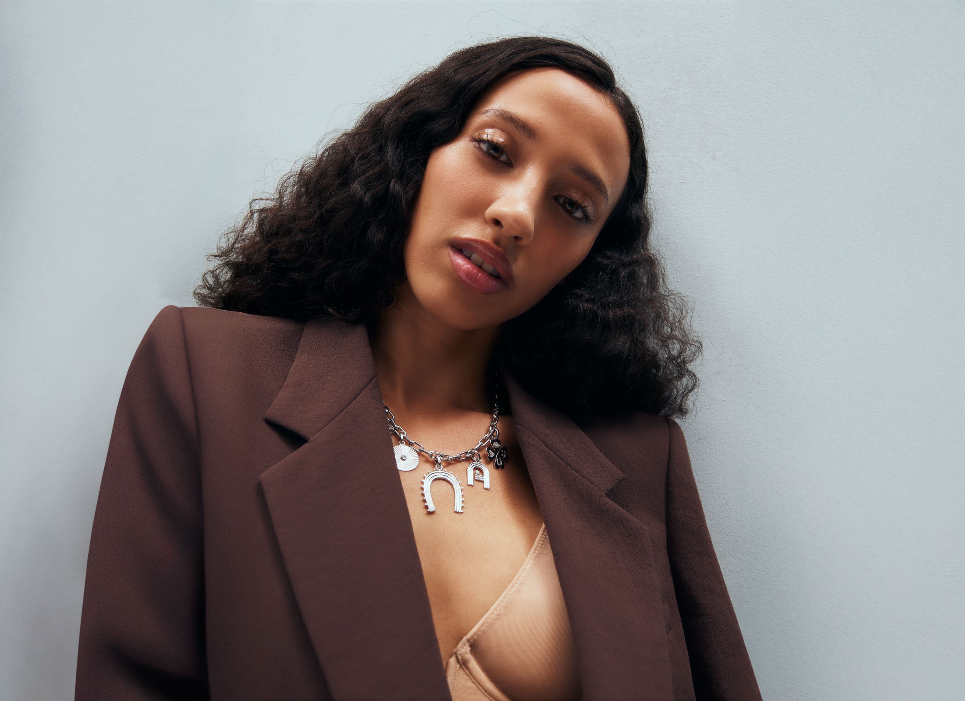 A woman wearing a charm necklace.