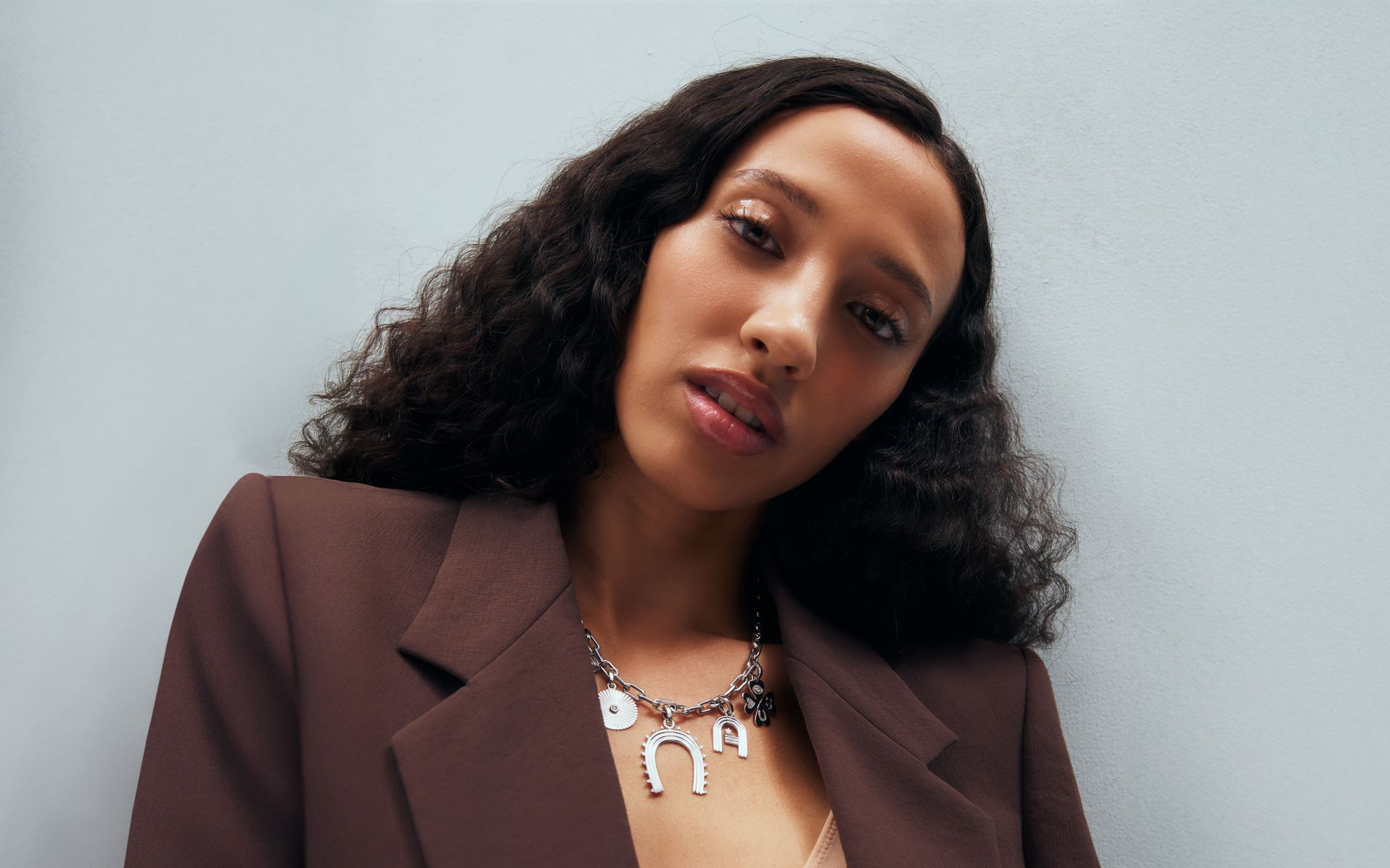 A woman wearing a charm necklace.