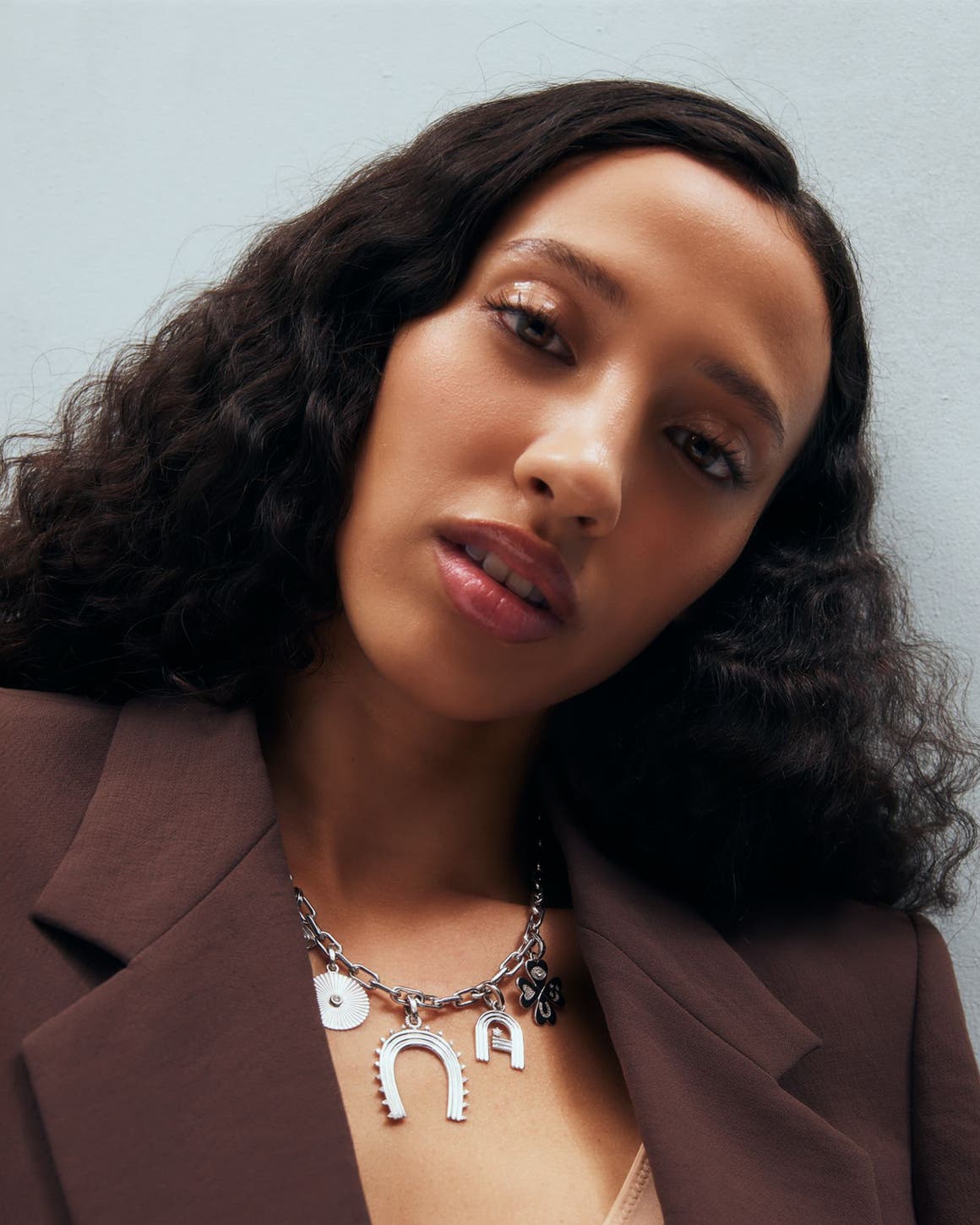 A woman wearing a charm necklace.