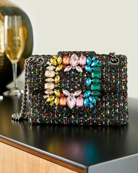 Product shot of black clutch with colorful jewels.