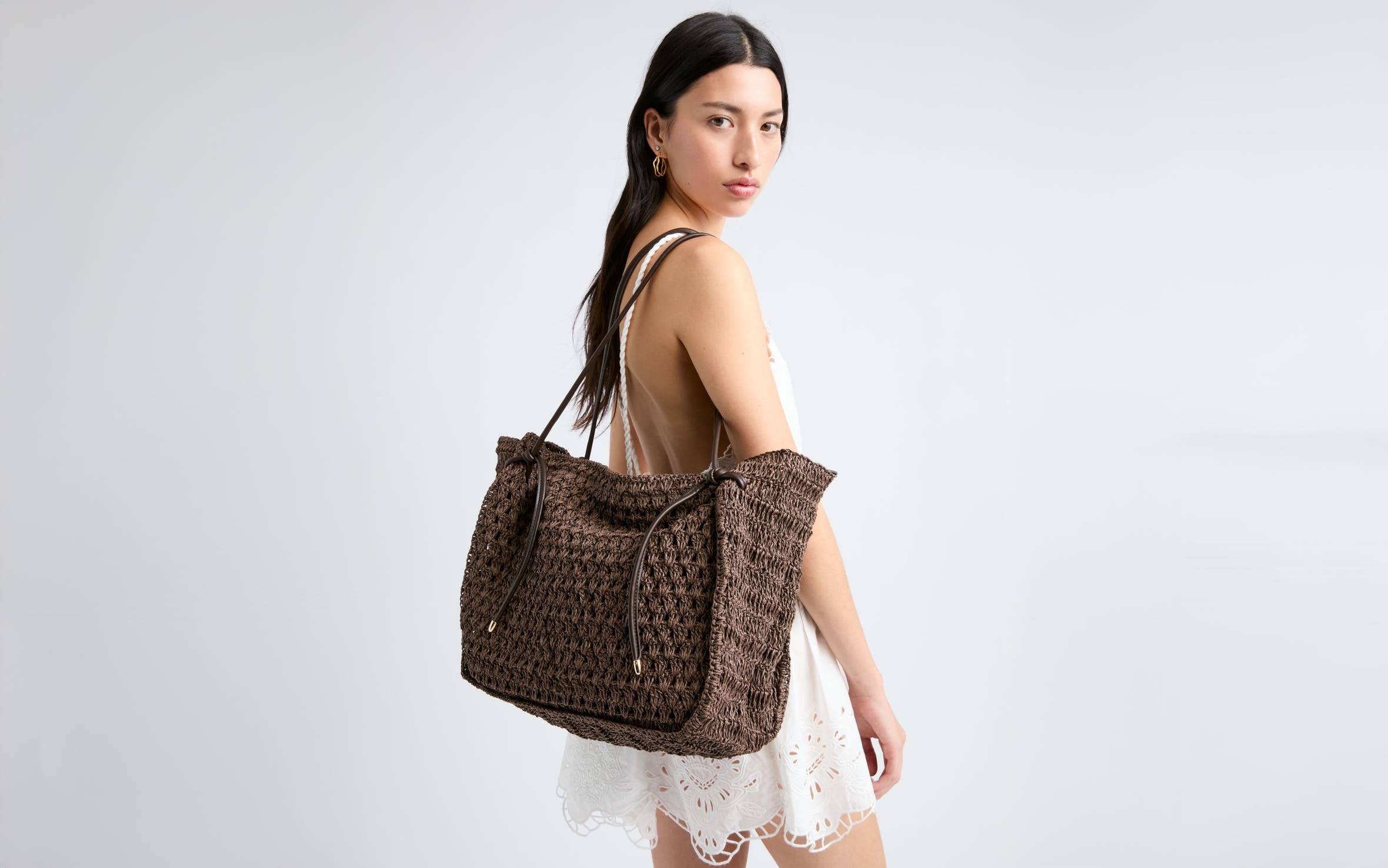 A woman carrying a large woven bag. 