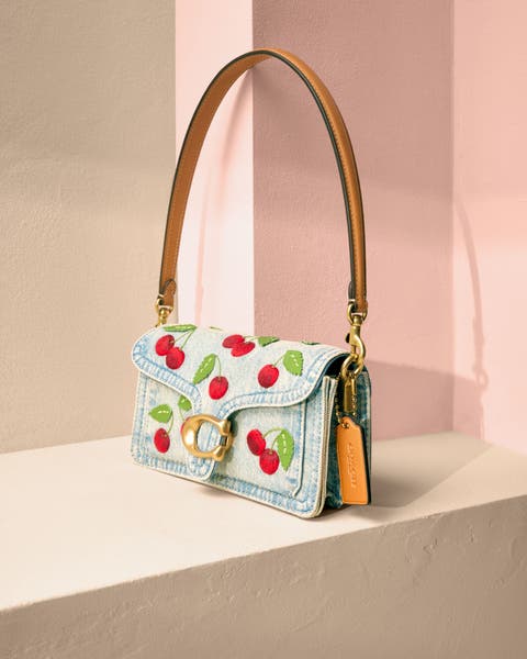 A cherry-embroidered denim handbag.