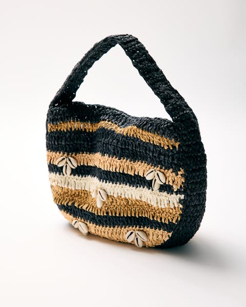 A woven bag with shell details. 