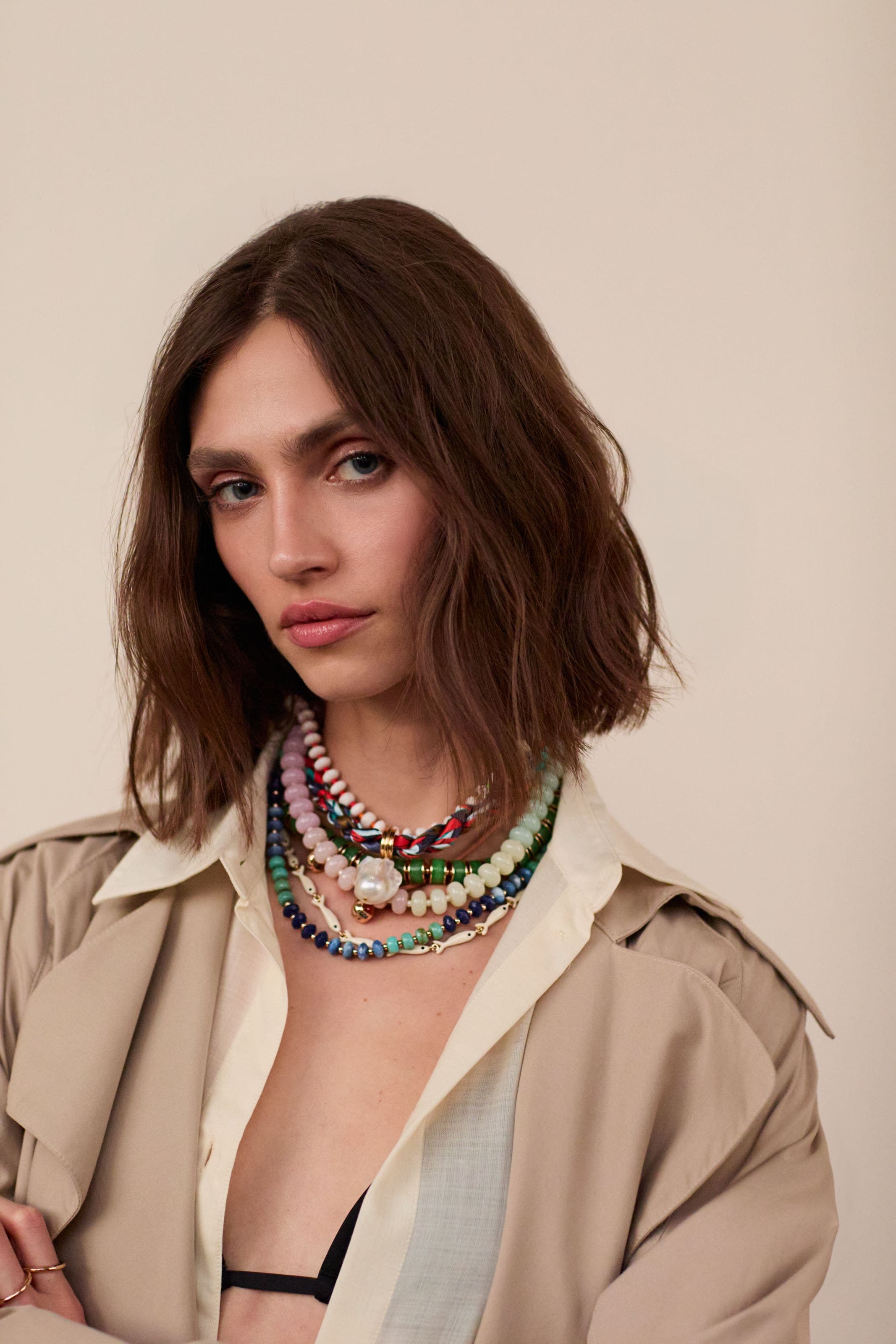 A woman wearing several beaded necklaces.