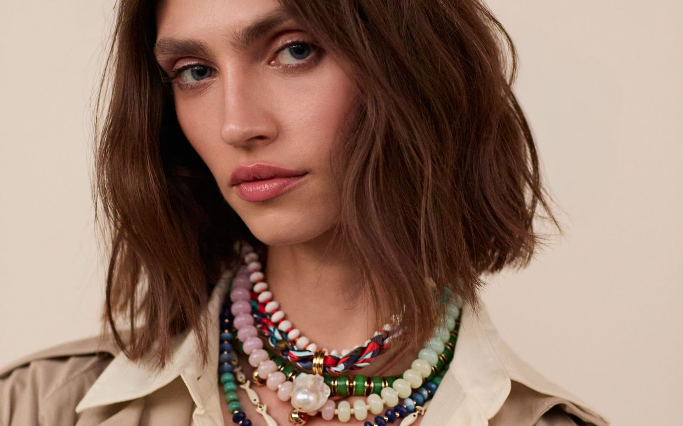 A woman wearing several beaded necklaces.