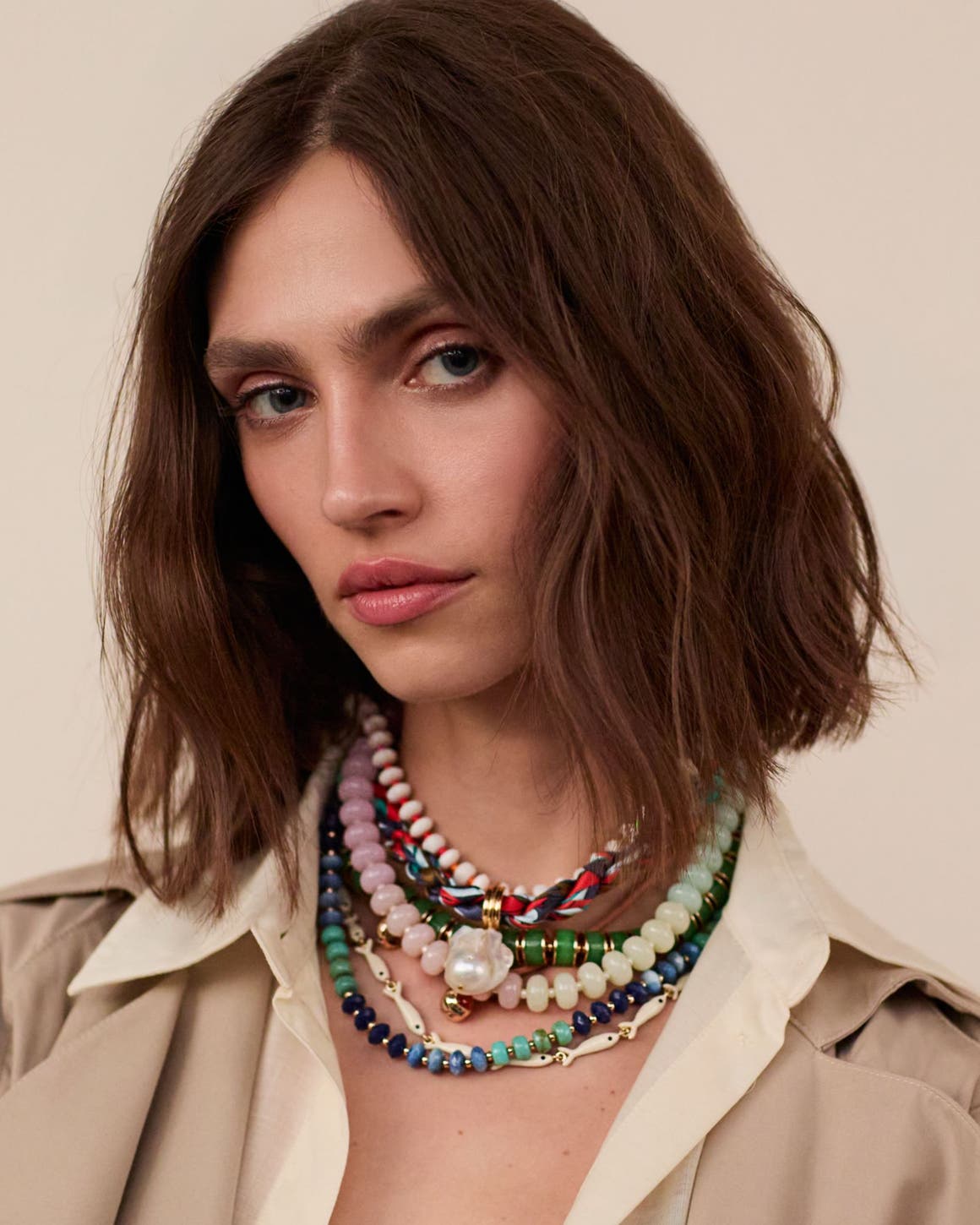A woman wearing several beaded necklaces.