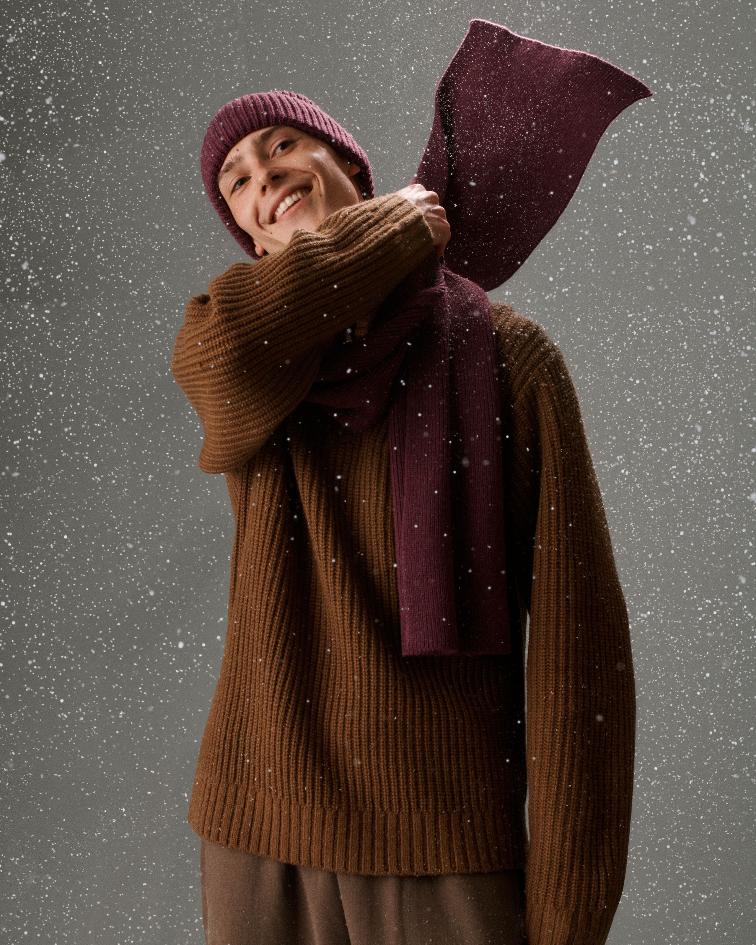 A man wearing a matching scarf and beanie. 