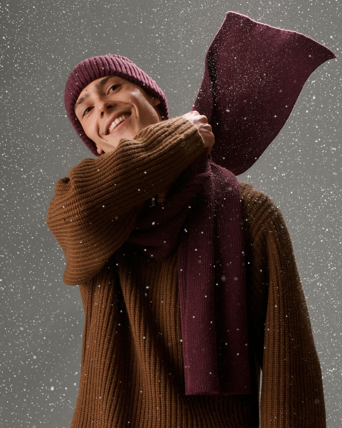 A man wearing a matching scarf and beanie. 