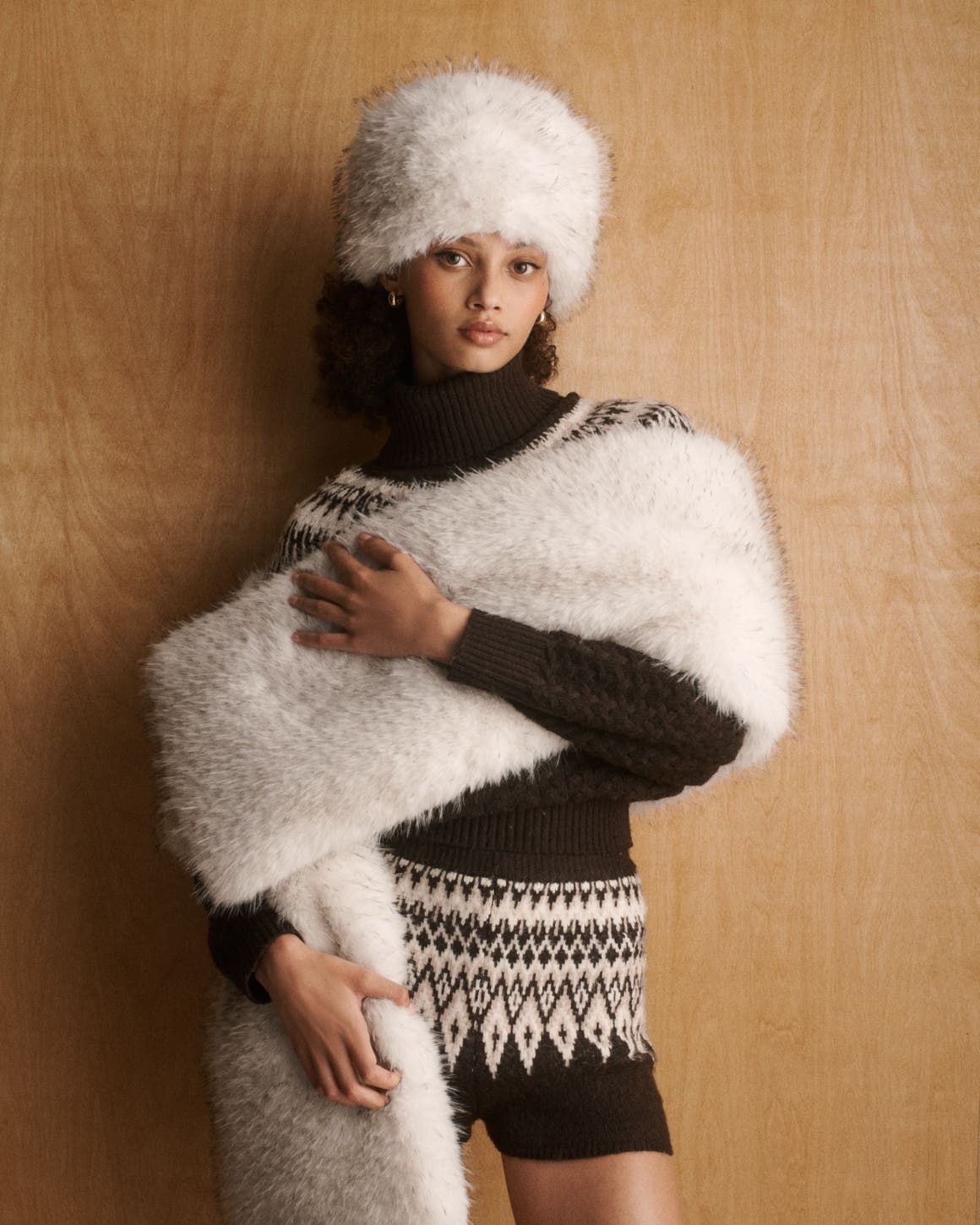 A woman wearing a knit set layered with cold weather accessories.
