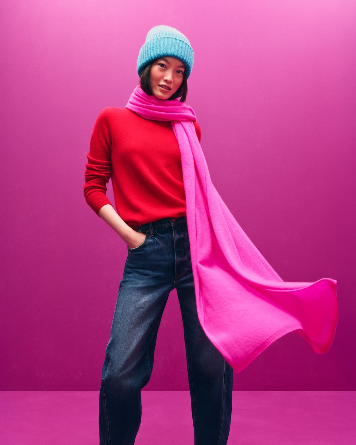 Alt text: A woman in a blue hat, red sweater and pink scarf.