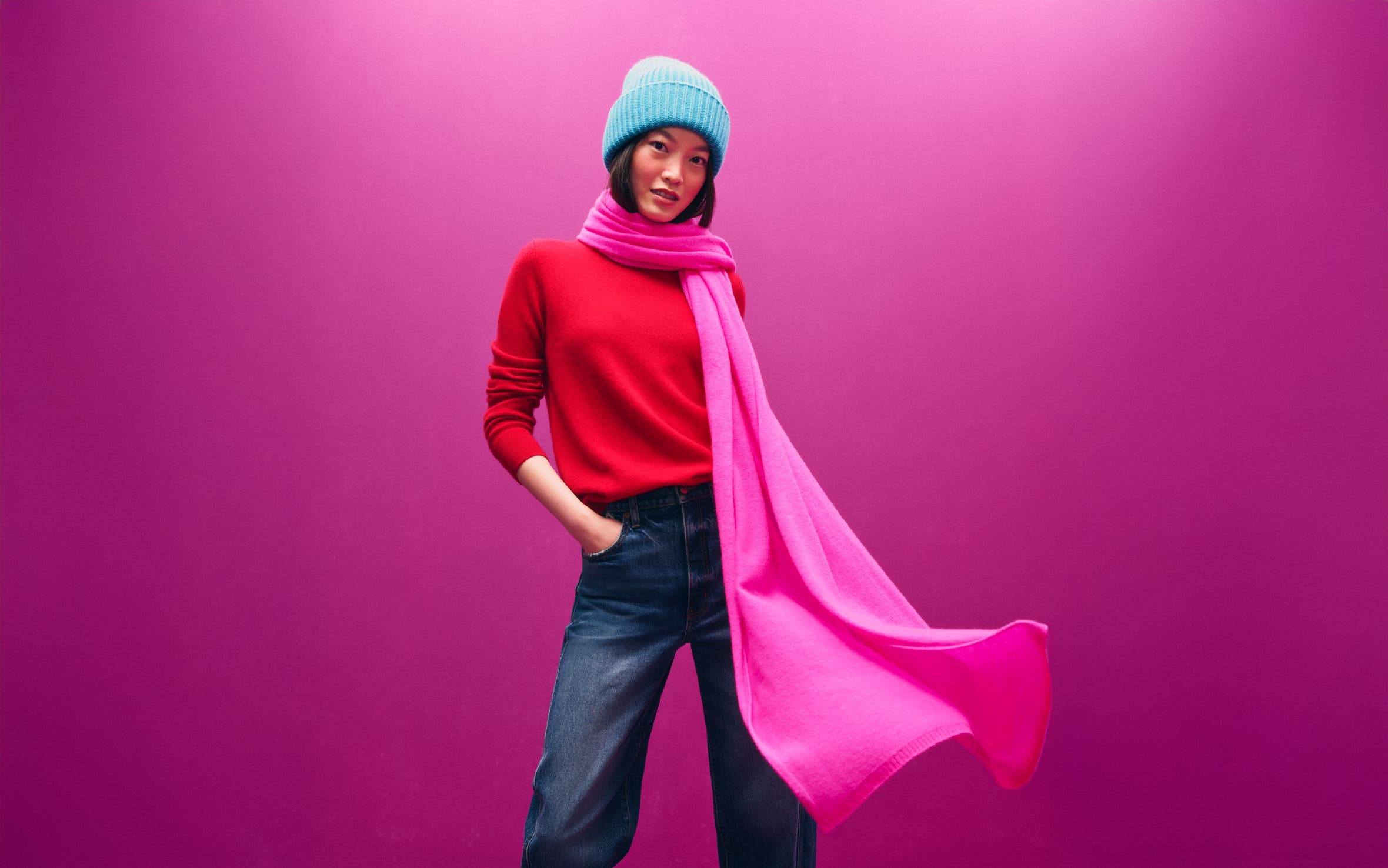 Alt text: A woman in a blue hat, red sweater and pink scarf.