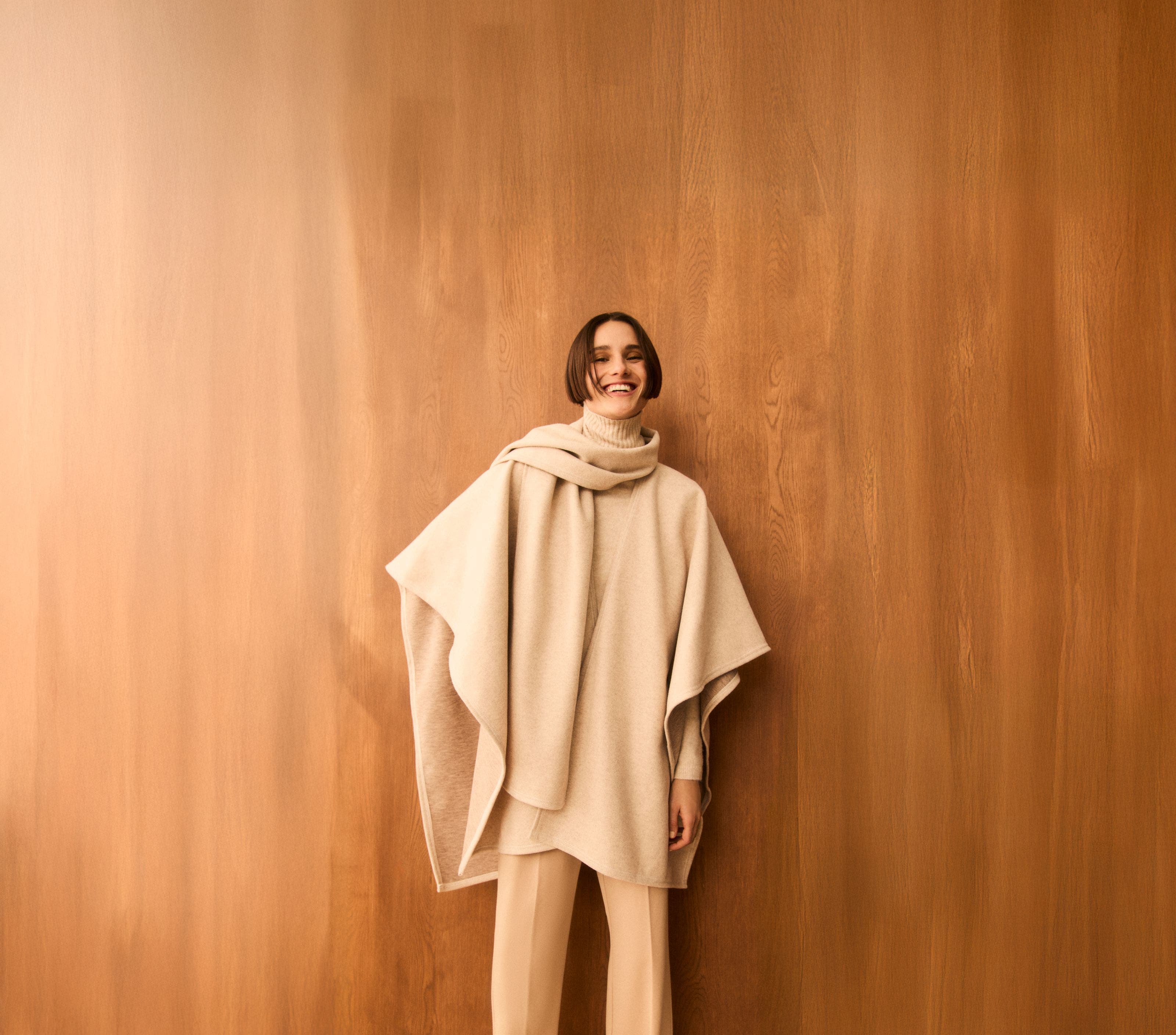 A woman wearing a beige poncho.