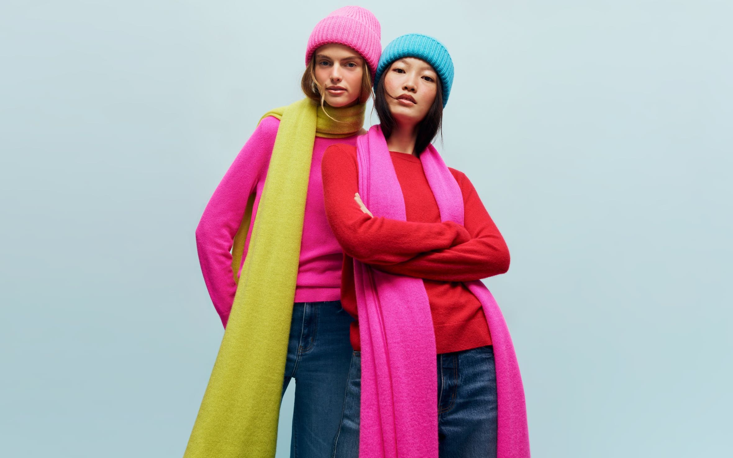 Two women wearing colorful hats and scarves.