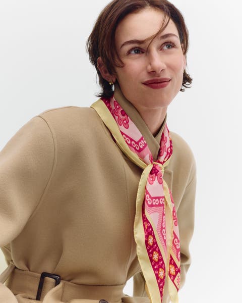 A woman wearing a pink neck scarf.