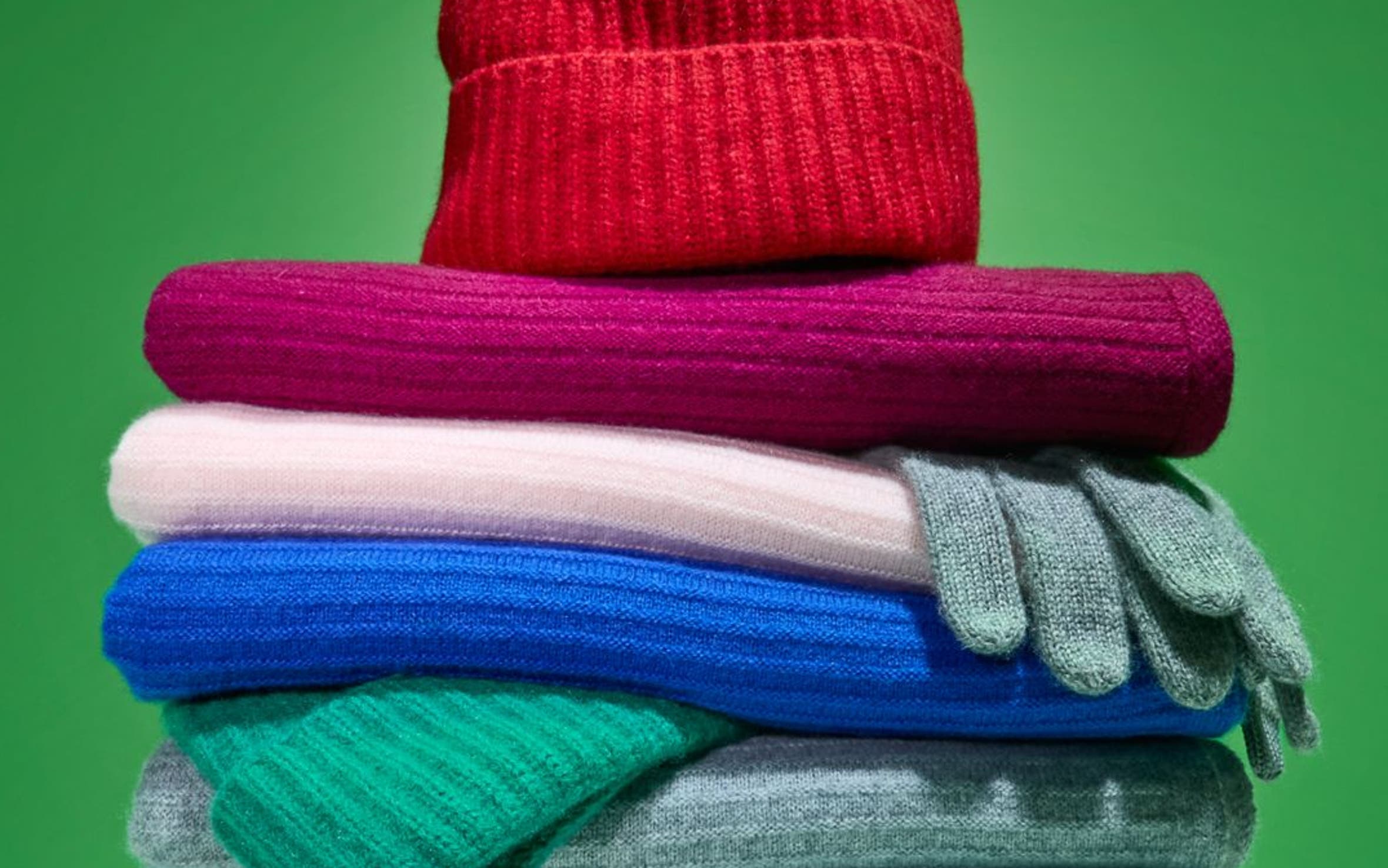 A stack of cashmere scarves, gloves and beanies.