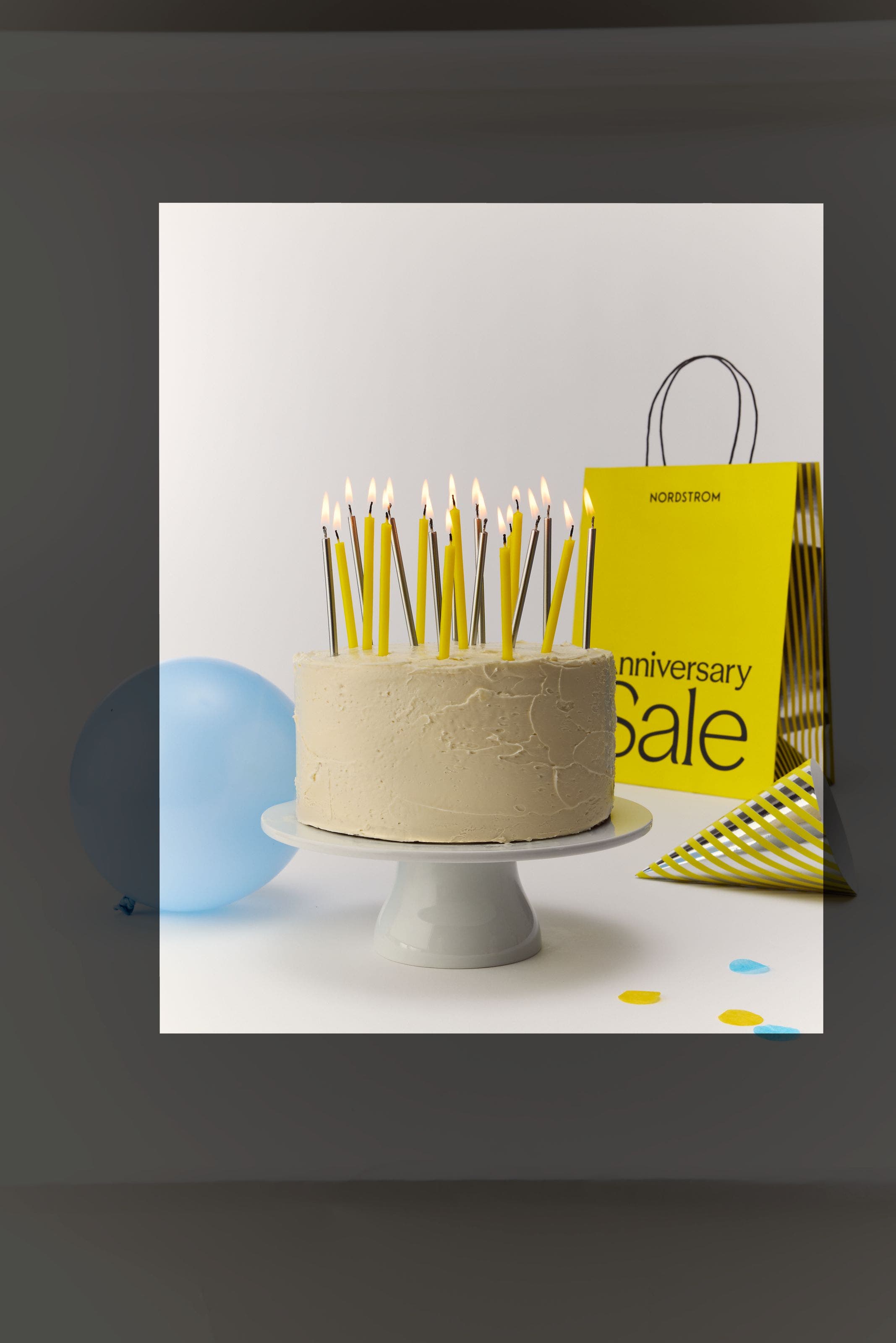a birthday cake and Anniversary Sale shopping bag