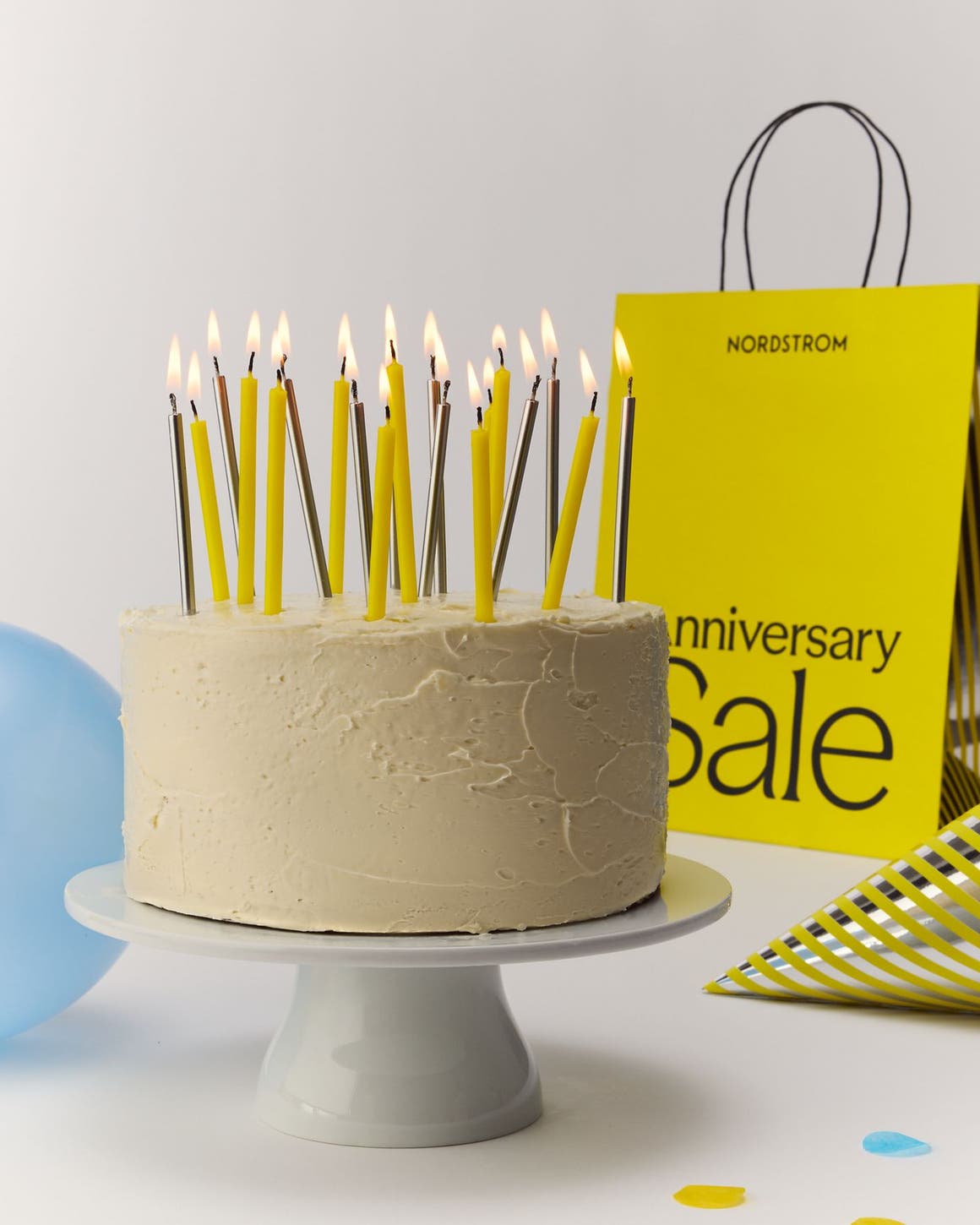 a birthday cake and Anniversary Sale shopping bag
