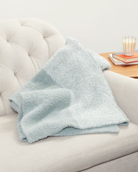 A chair with a striped throw.