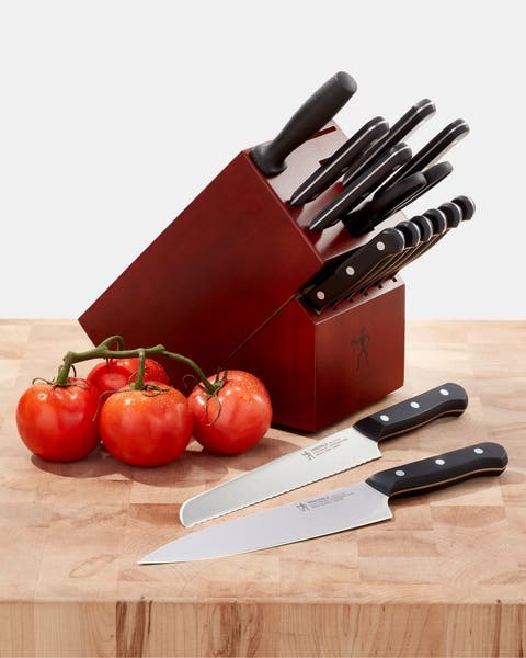 A set of knives on a butcher block.