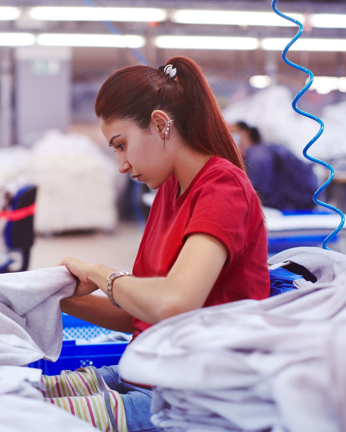 Woman working on a garment on a sewing machine.