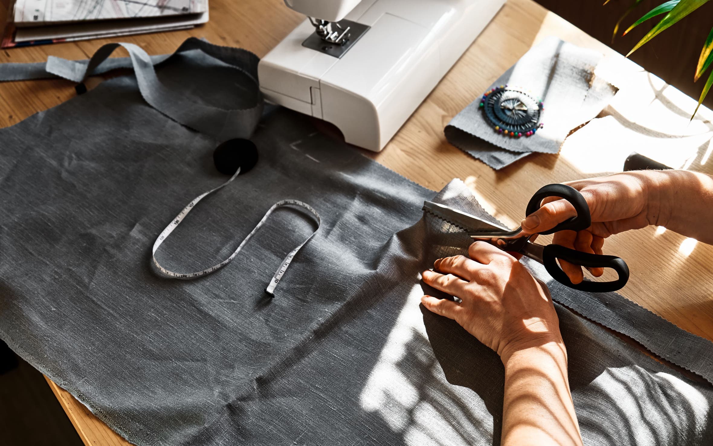 Hands using scissors to cut fabric.