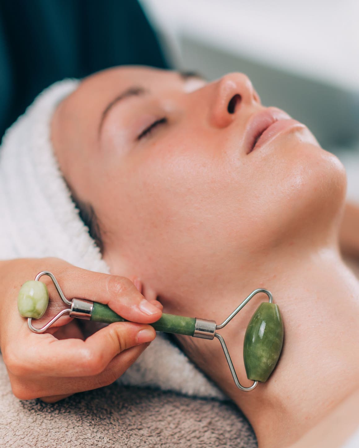 A woman having a massage with a facial roller.
