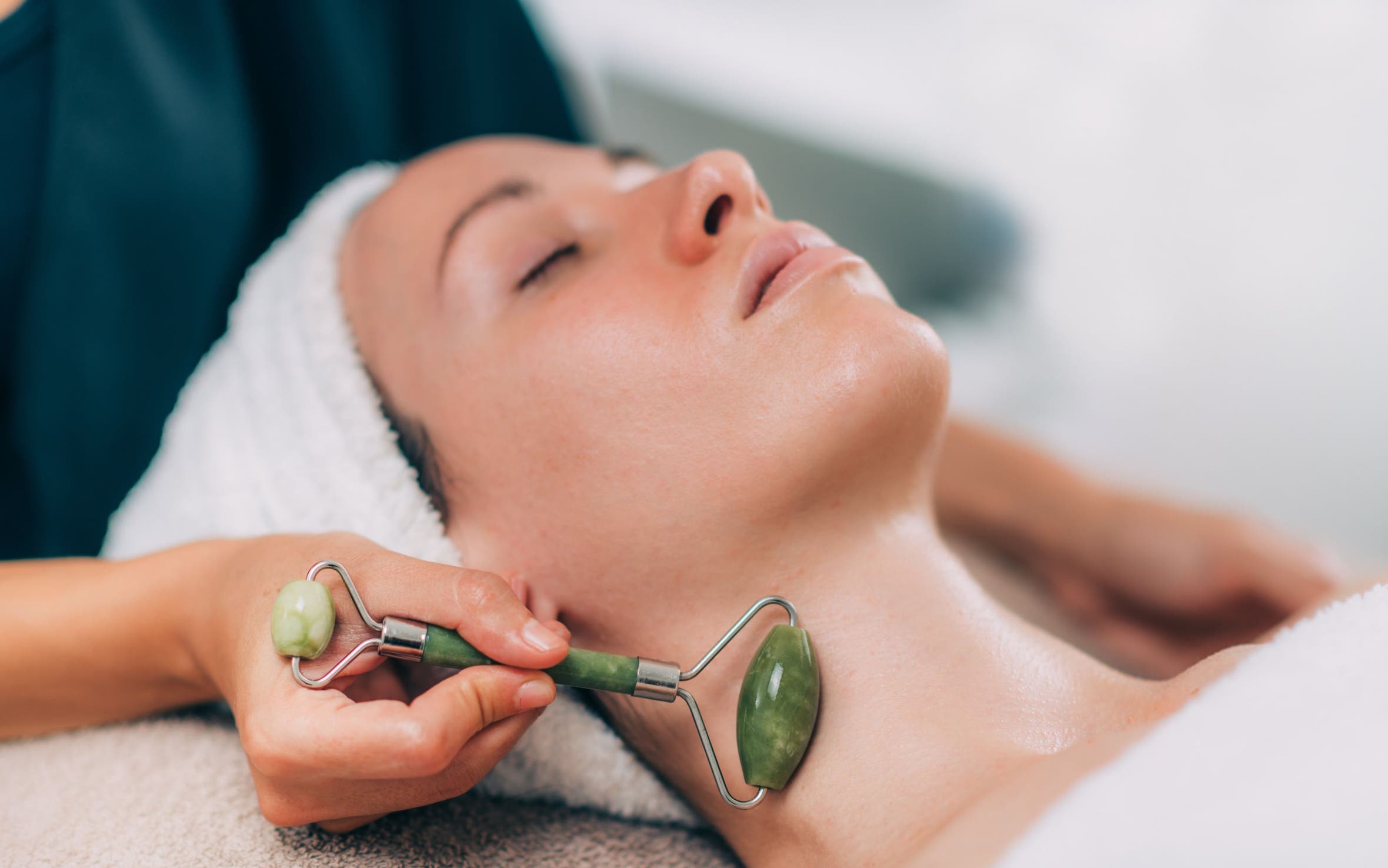 A woman having a massage with a facial roller.