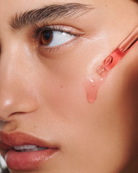 A woman applying skincare. 