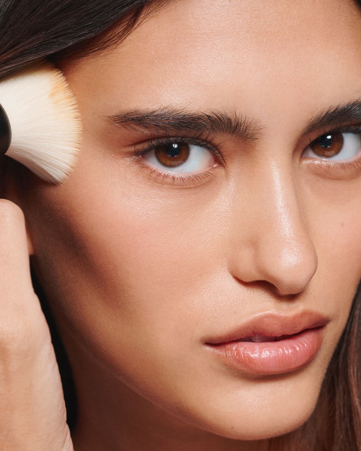 A woman applying makeup.