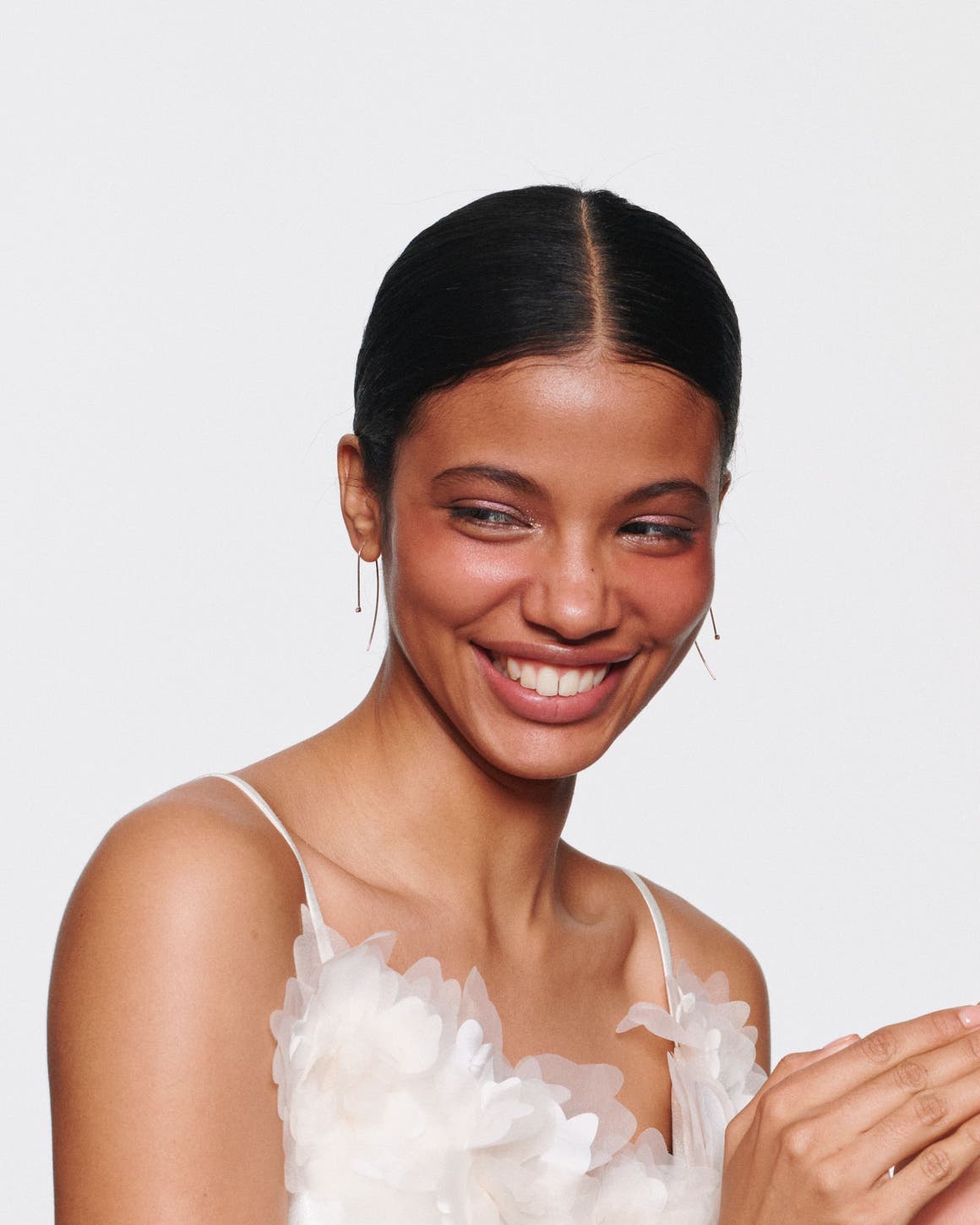 A smiling woman with sparkly eyeshadow.