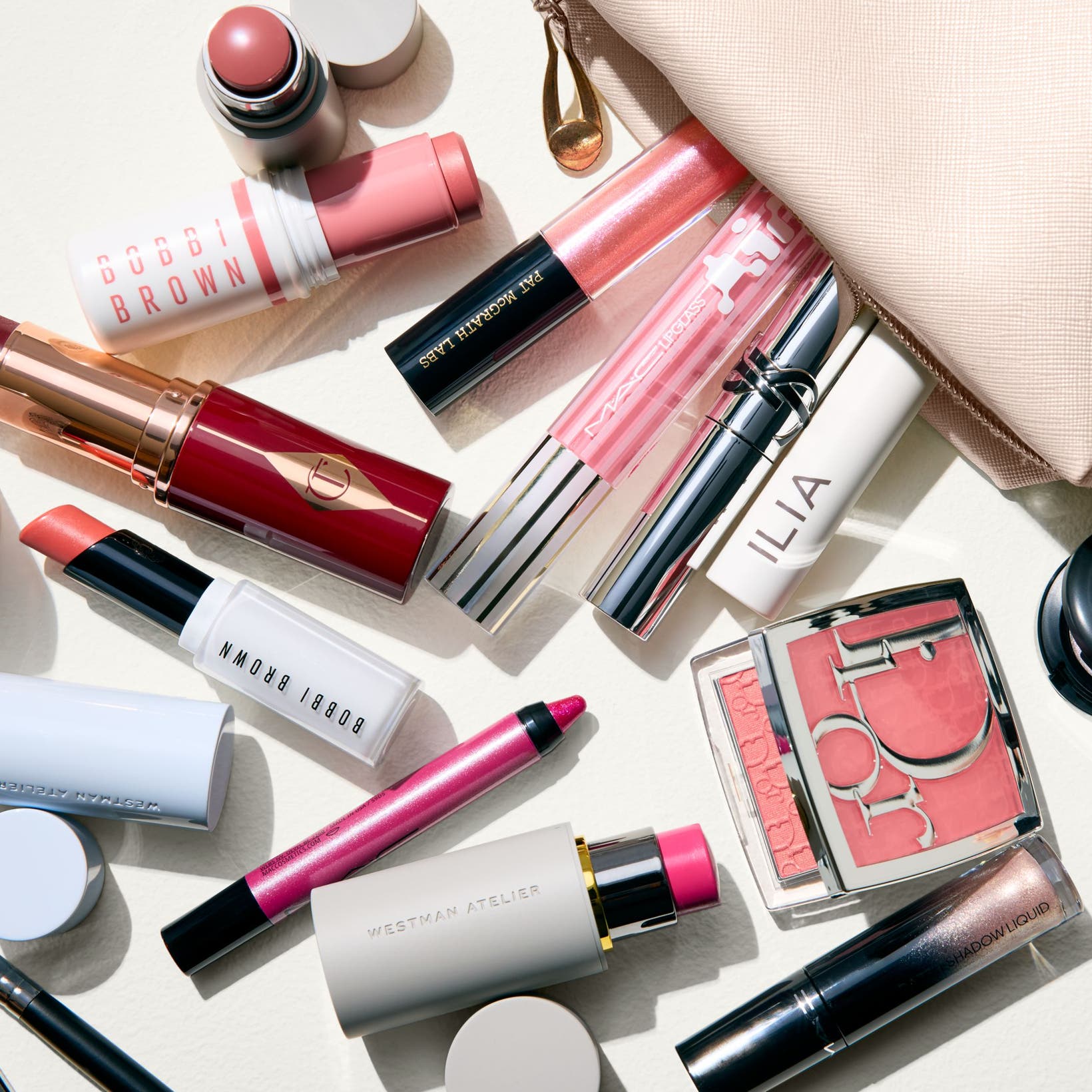 An assortment of makeup products in various shades of pink.