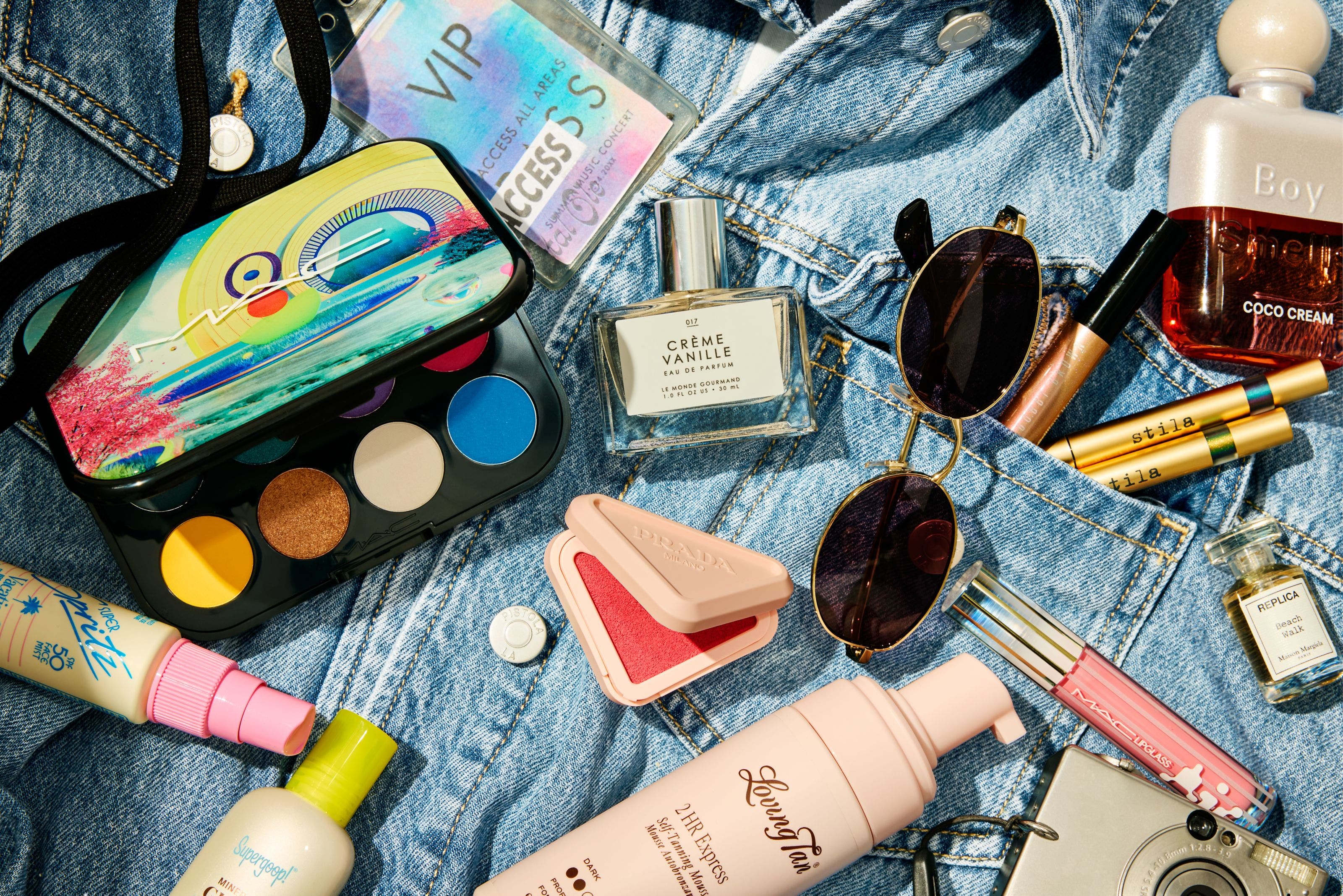 Assorted makeup spread out on a jean jacket.