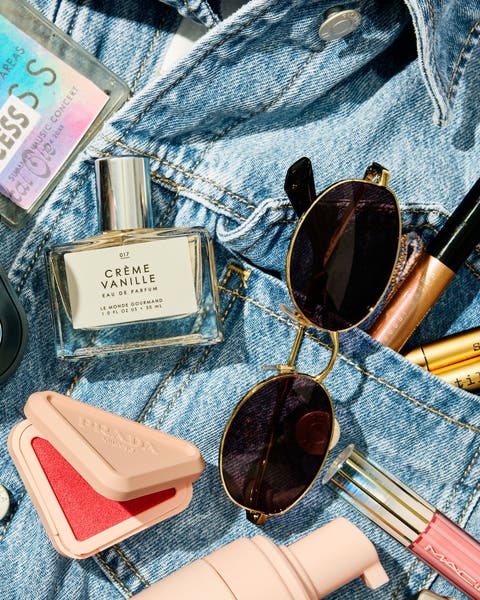 Assorted makeup spread out on a jean jacket.