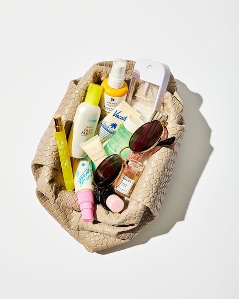An assortment of summer beauty and SPF products in a textured bag.