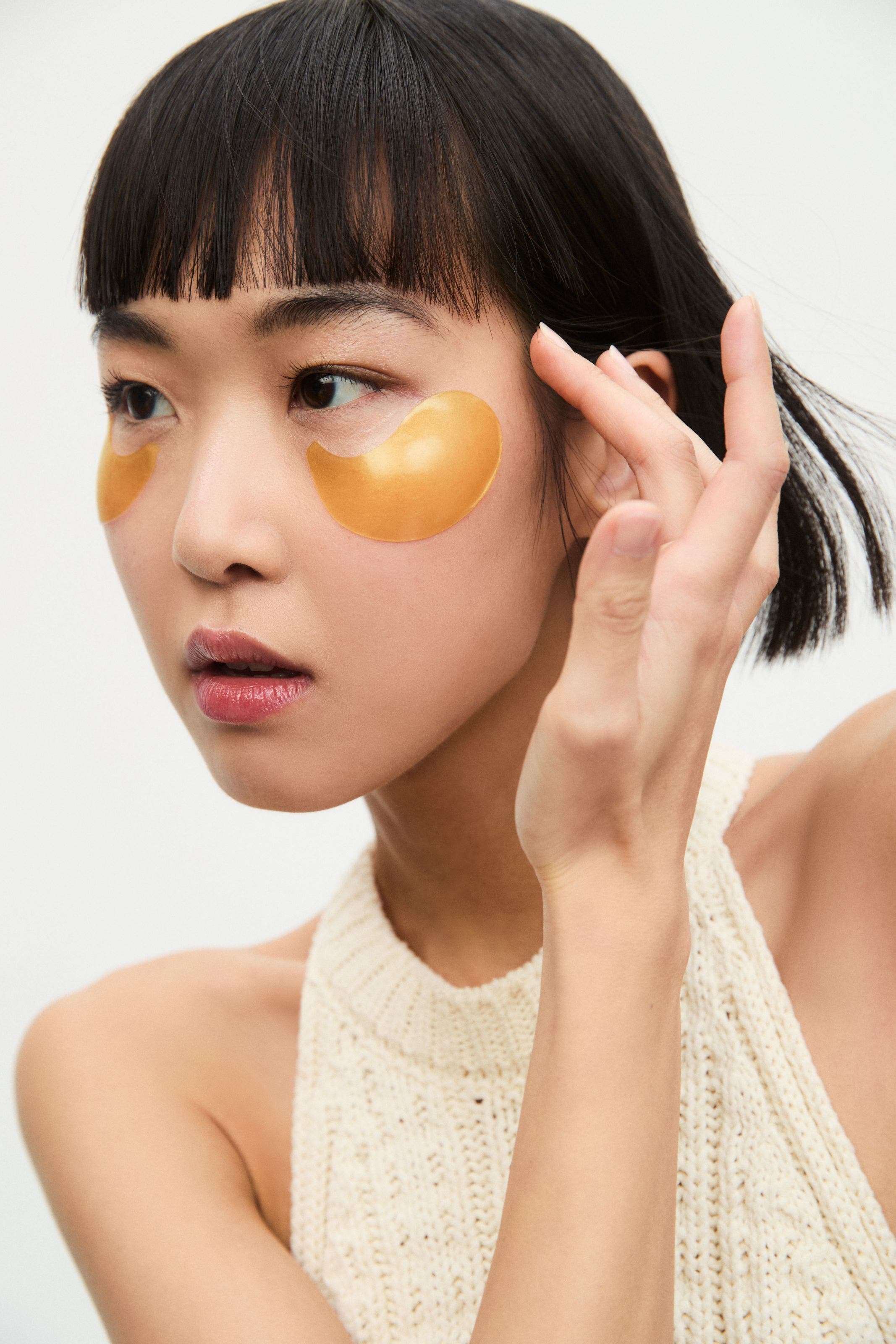 A woman applying eye gels. 
