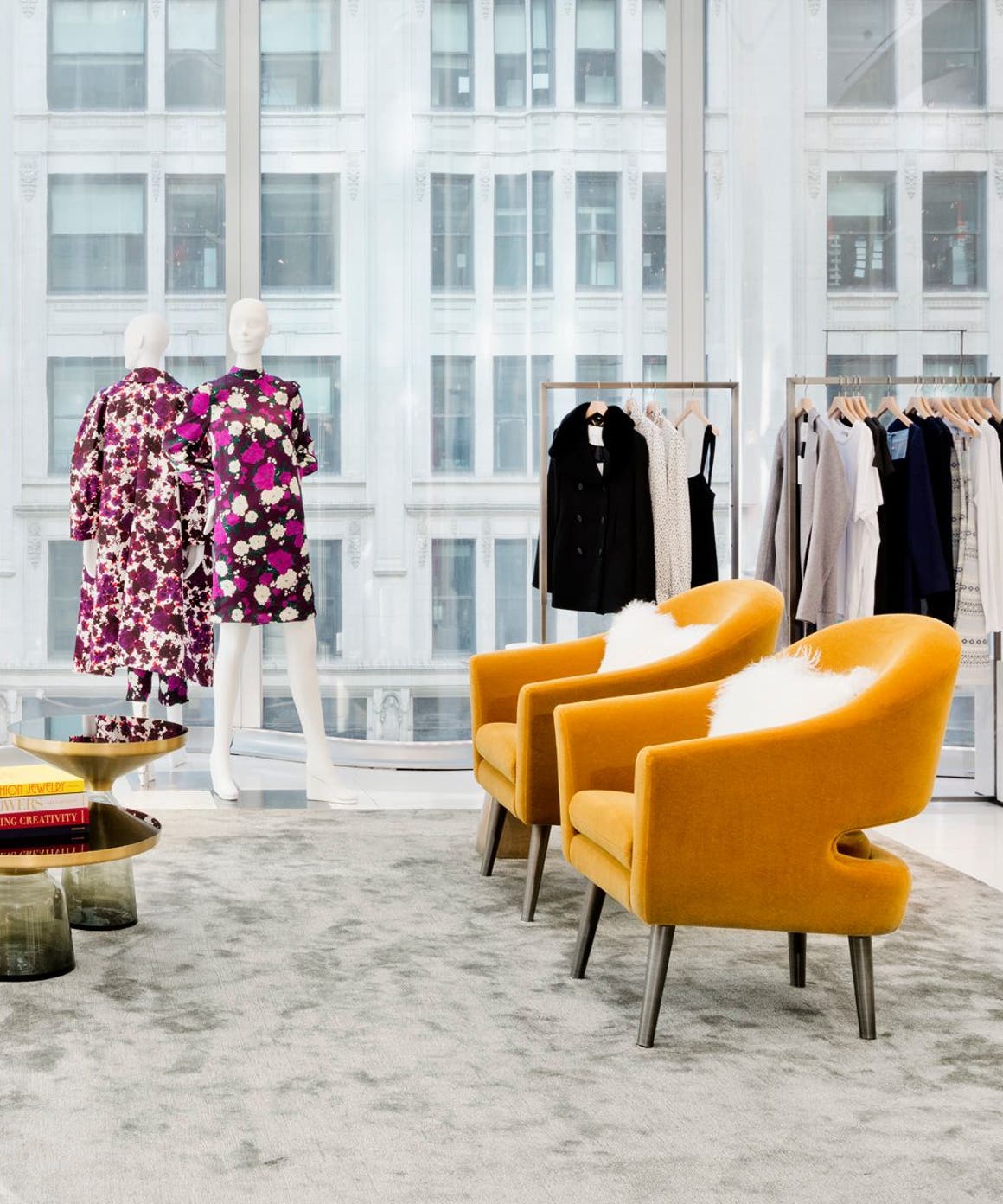 A Nordstrom showroom with clothing and lounge chairs.
