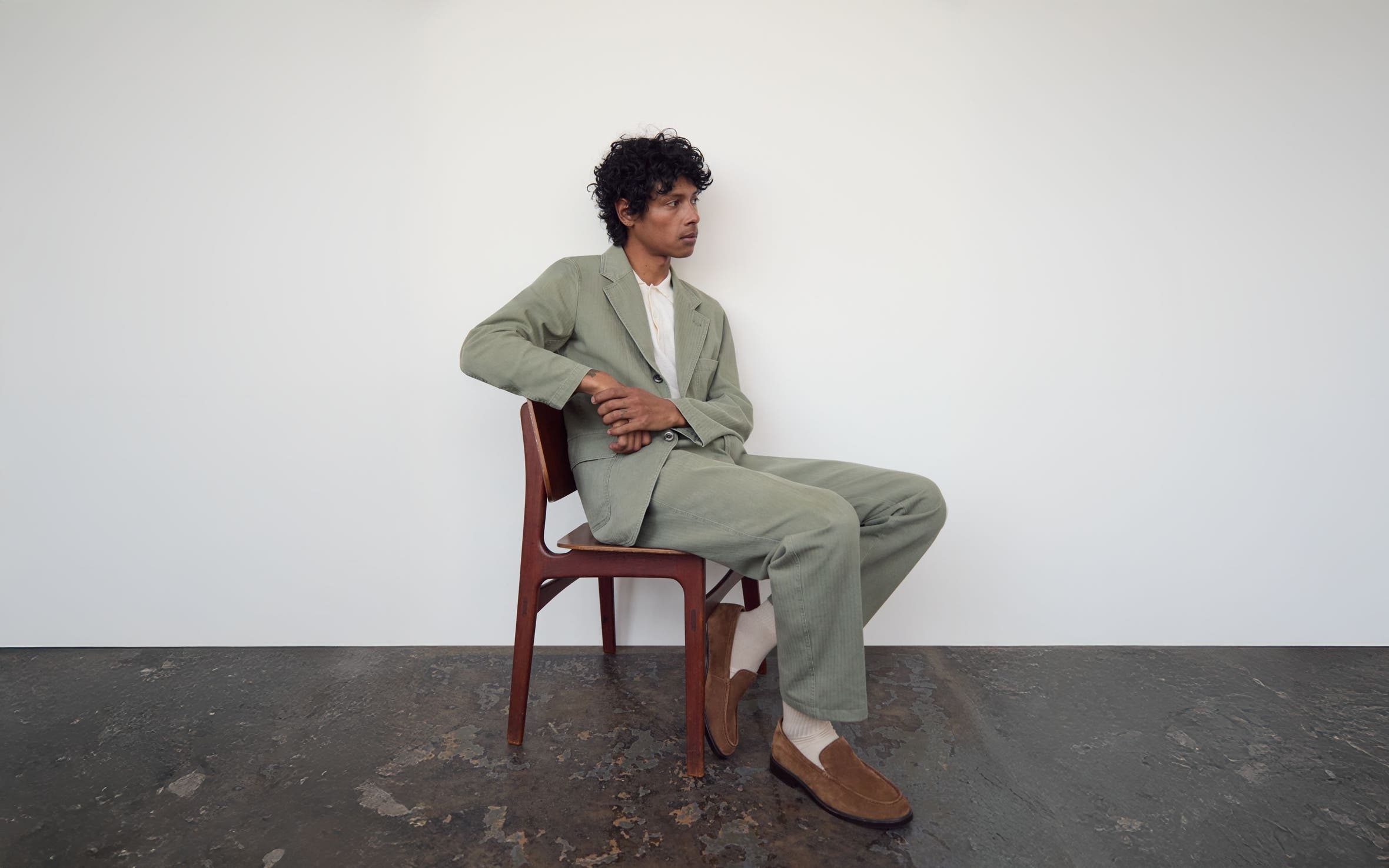 Man wearing a relaxed suit with suede loafers.
