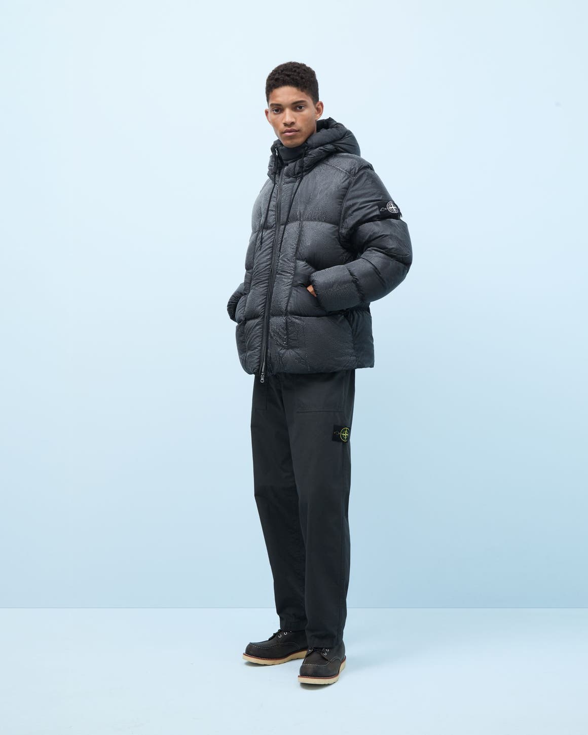 Man wearing a puffer, pants and boots.