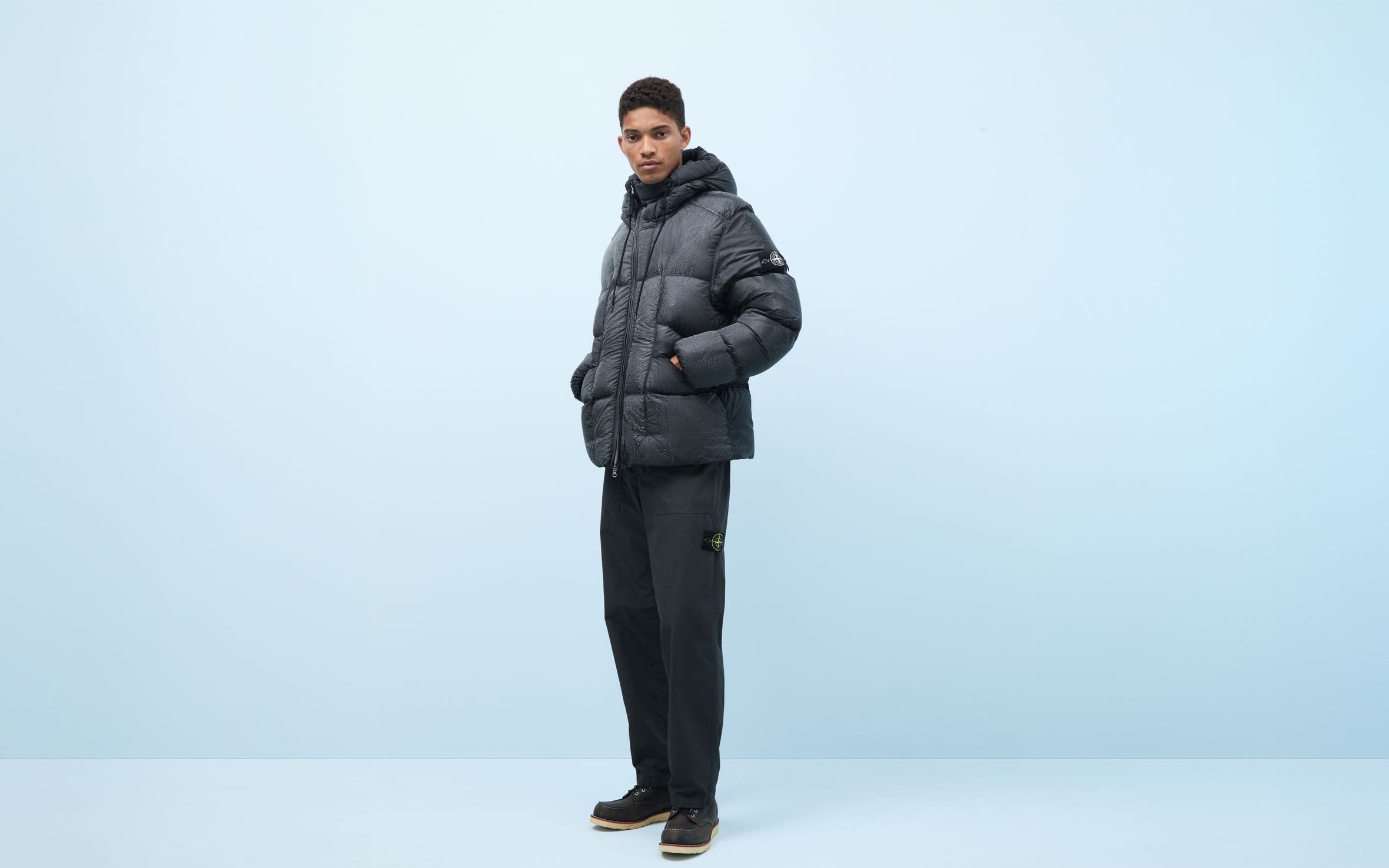 Man wearing a puffer, pants and boots.