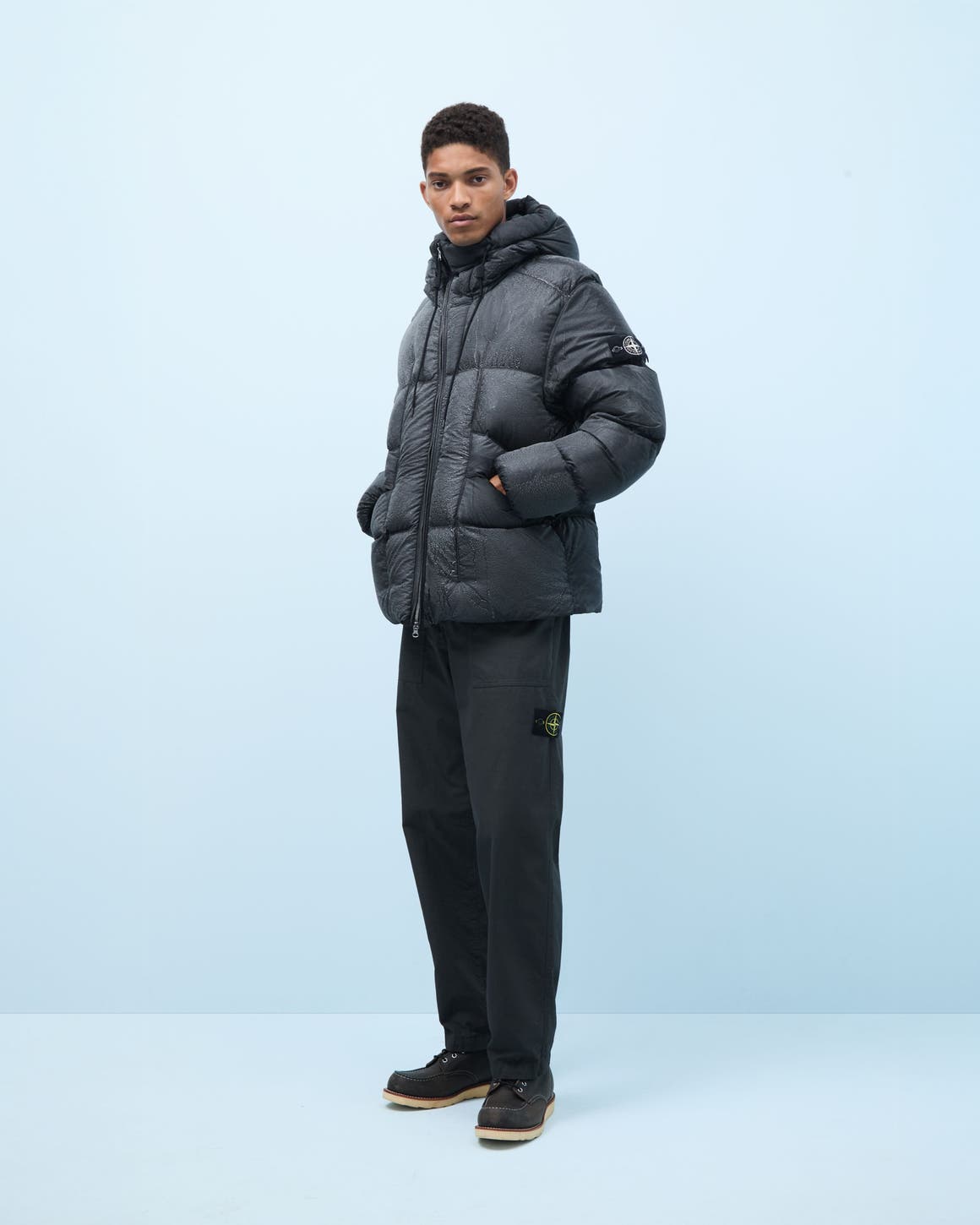 Man wearing a puffer, pants and boots.