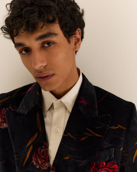 A man wearing a floral print velvet jacket.