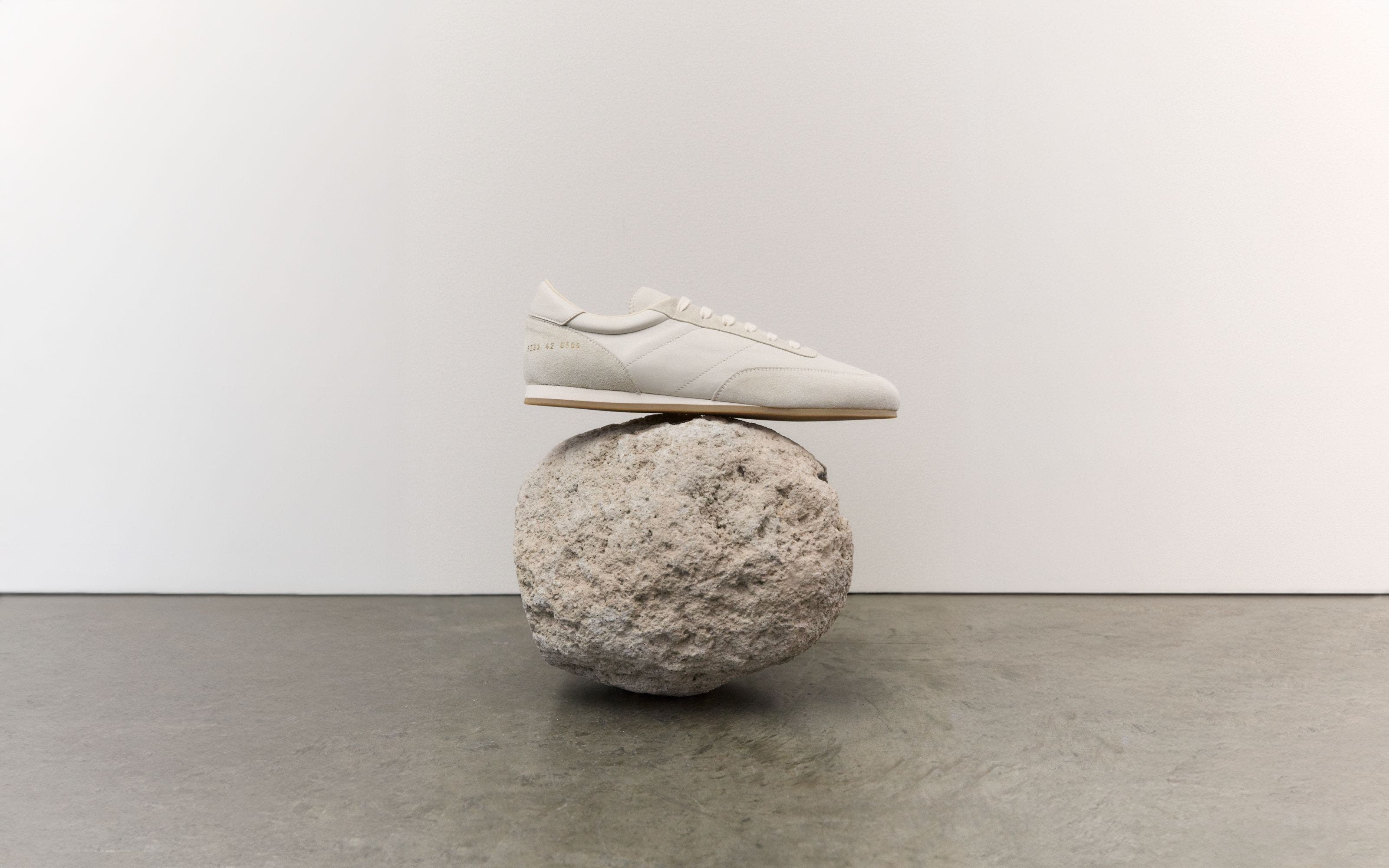A sneaker balanced on a rock.