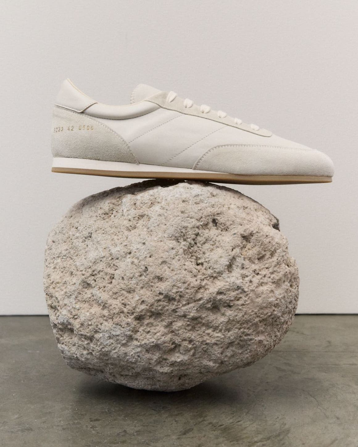 A sneaker balanced on a rock.