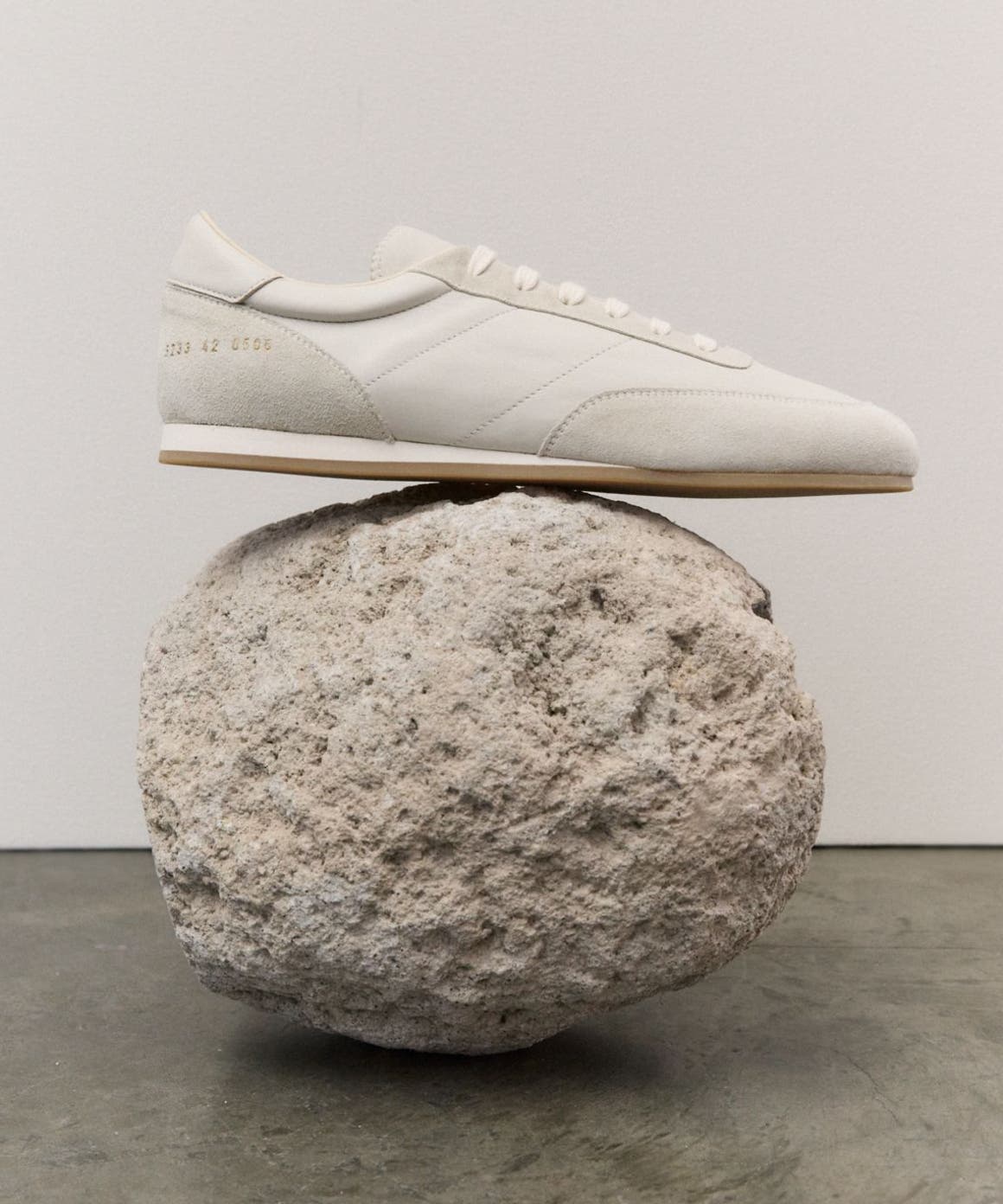 A sneaker balanced on a rock.
