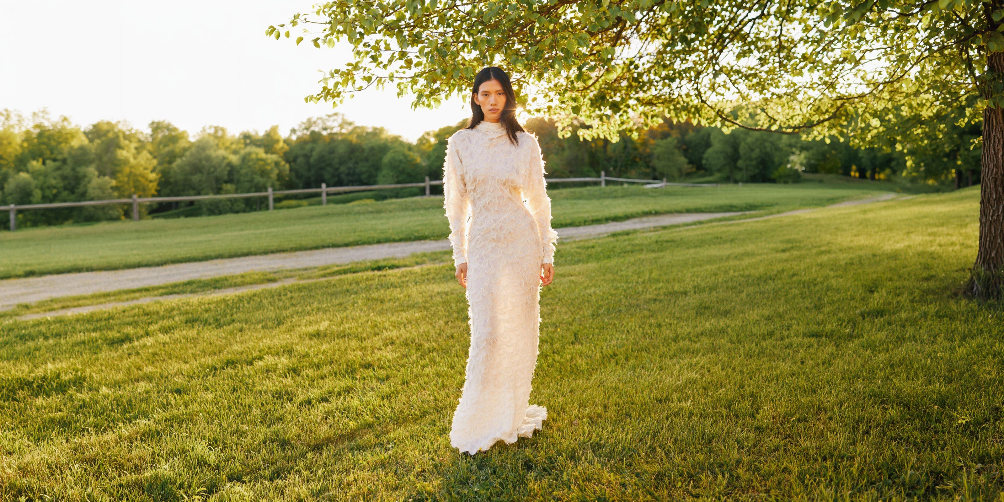 A woman wearing a long white lace gown.