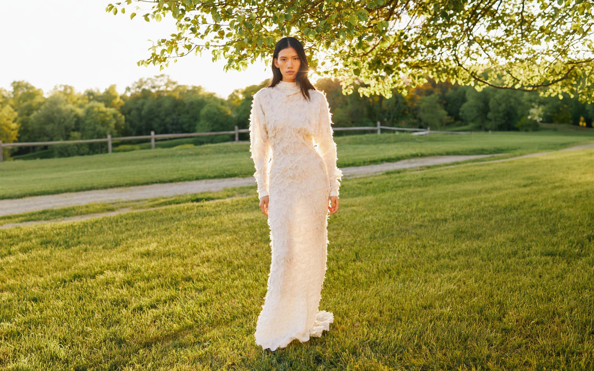 Woman in full-length white lace dress.